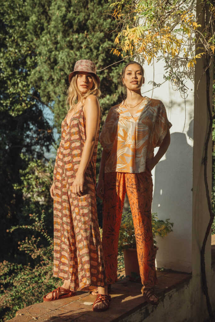 Two female models wearing a jumpsuit and a T-shirt and pants from SISSEL EDELBO outside in nature