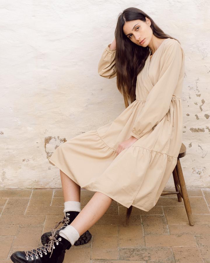 Model wearing a beige midi dress from Beaumont Organic