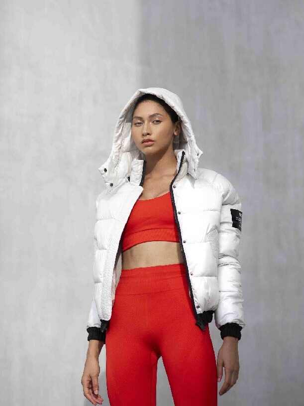 Model wearing red leggings and sportsbra and silver/white puffer jacket from Ecoalf