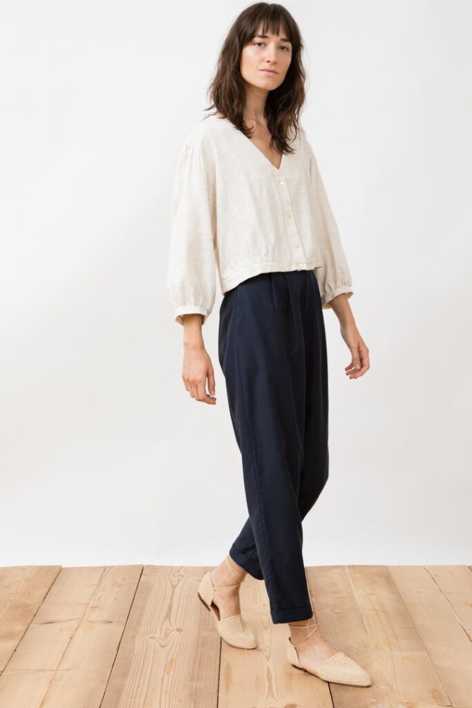 Model wearing dark blue pants with an off-white shirt from Jungle Folk