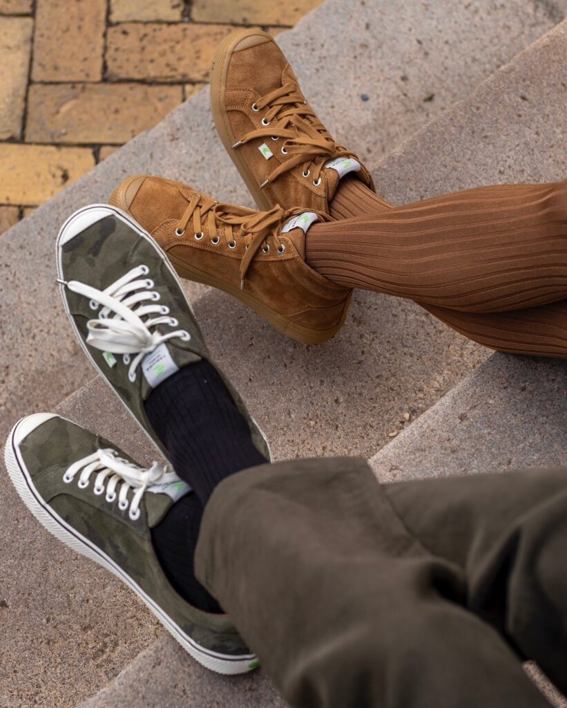 Male and female models wearing light brown sneakers and olive coloured sneakers from CARIUMA