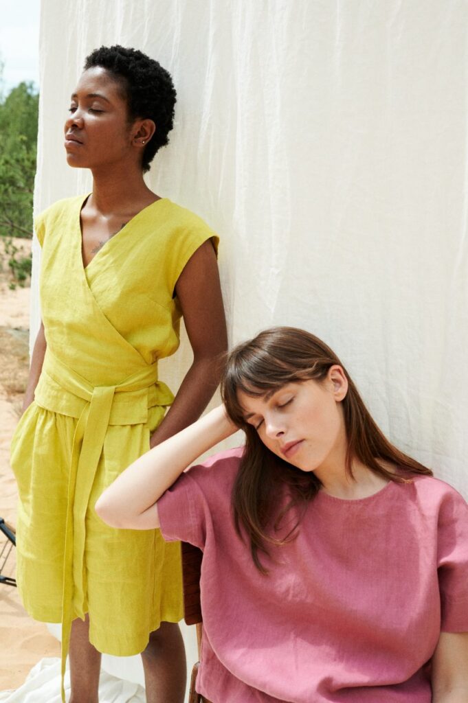 Two models wearing a yellow wrap top and matching wide shorts and a pink top from Linen Fox