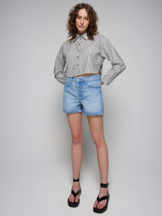 Model wearing light blue denim shorts and cropped striped black and white button-up shirt from Nobody Denim
