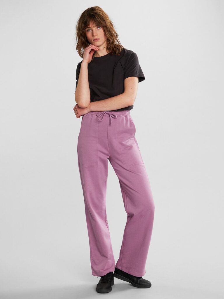 Model wearing pink wide sweatpants with black T-shirt from Dedicated