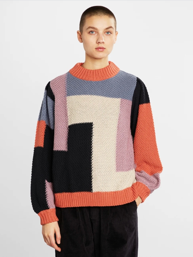 Model wearing multi coloured block pattern sweater with black pants from Dedicated