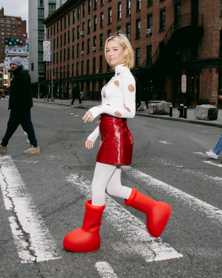 Sarah Snyder wearing MSCHFs Big Red Boot with a white and red outfit
