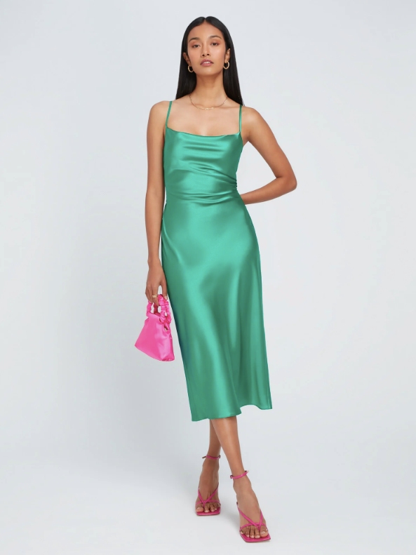 Model wearing a blue/green midi length dress from sustainable brand OMNES