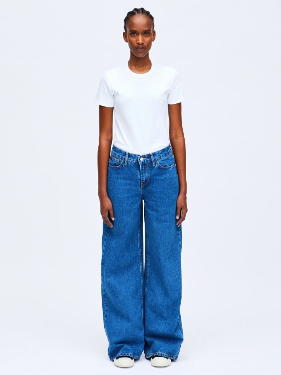 Model wearing mid blue wide leg jeans from sustainable brand HNST