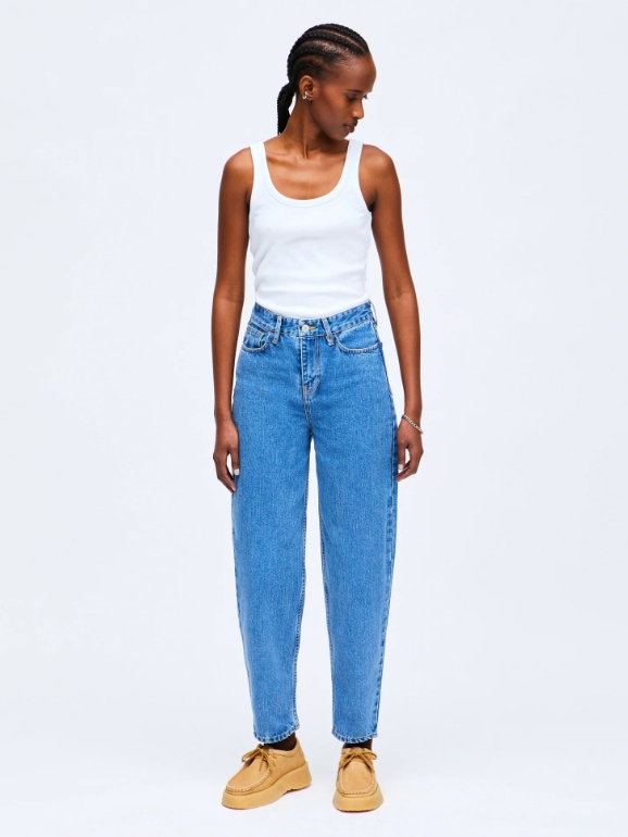Model wearing mid blue mom jeans from sustainable brand HNST