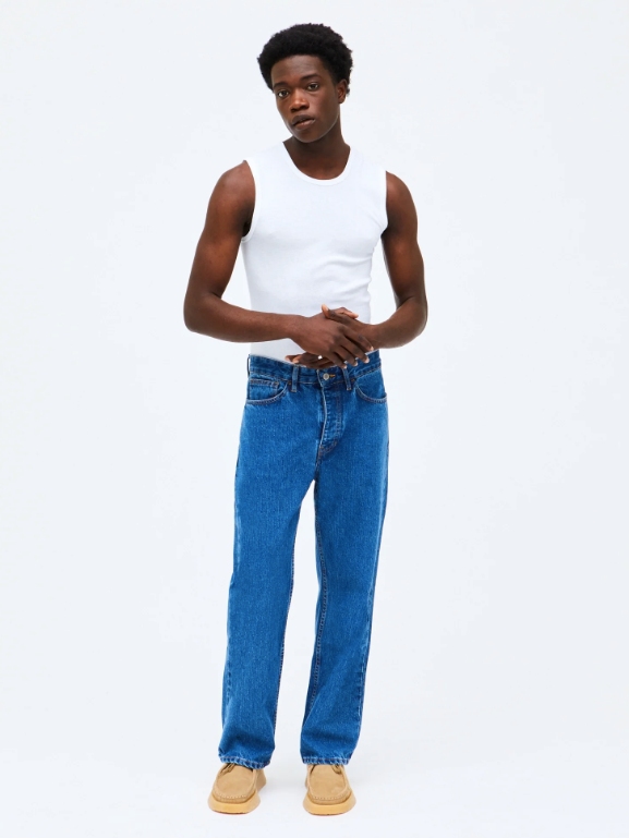 Model wearing mid blue jeans from sustainable brand HNST