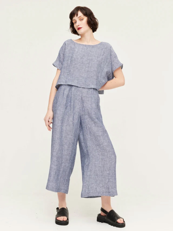 Model wearing grey wide leg cropped pants and a grey short sleeve top from sustainable brand Kuwaii