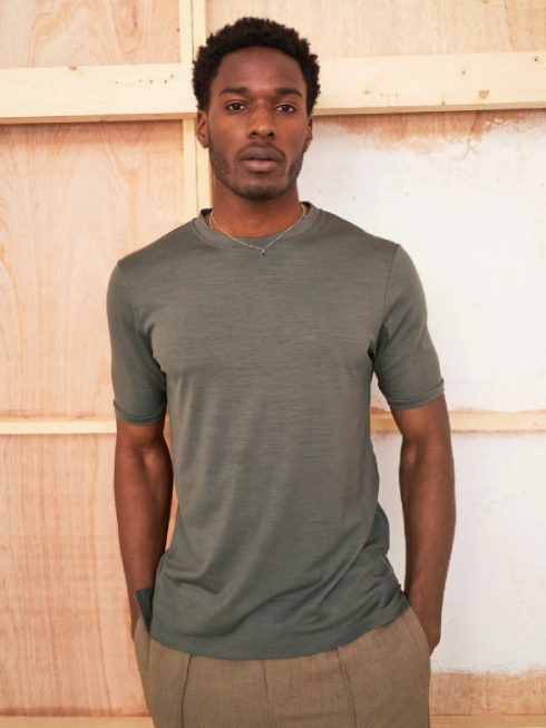 Male model wearing brown pants and a grey T-shirt from sustainable brand NEEM