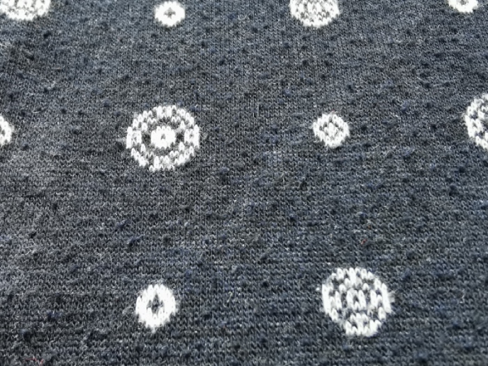 Dark blue sweater with a white print with pills on the surface